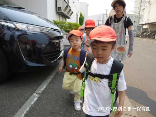 ひまわり組（５歳児）のお子さまとちゅりっぷ組（２歳児）のお子さまが仲良く手をつないで歩いている姿