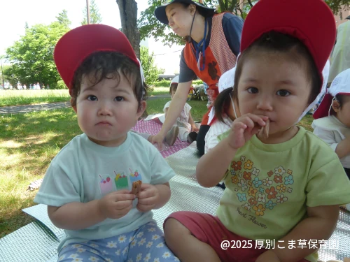 公園でおやつを食べているお子さまの様子