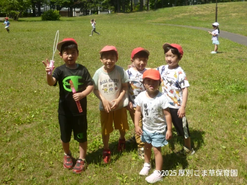 公園の芝生で楽しく遊んでいるお子さまの様子