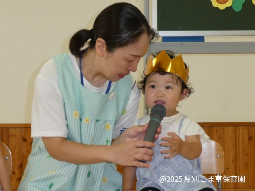 誕生会で質問される小さな誕生児の様子