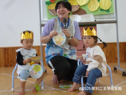 誕生カードを眺めている誕生児（１歳児）の可愛らしい様子