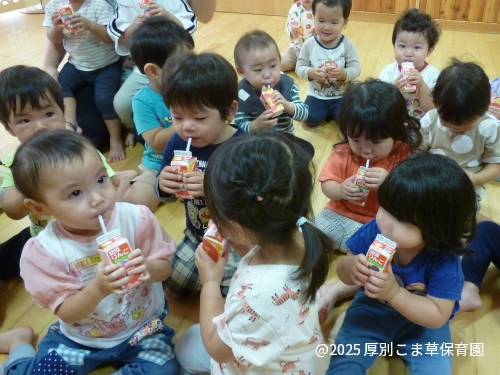 遠足出発前にジュースを飲んでいるたんぽぽ組(1歳児)の子どもたちの様子