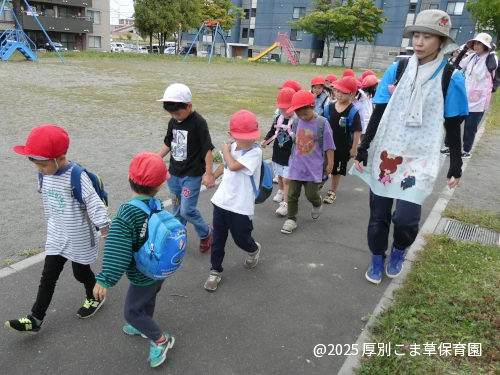 異年齢児同士で手をつないで保育園に戻っている子どもたちの様子