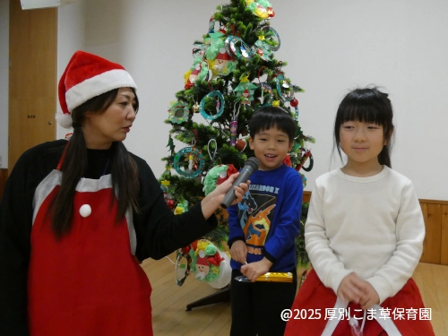 ひまわり組（５歳児）の子どもたちがツリーの飾りつけの制作発表をしている様子