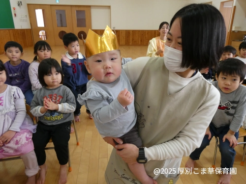 先生に抱っこされて入場するたんぽぽ組（０歳児）の誕生児の様子