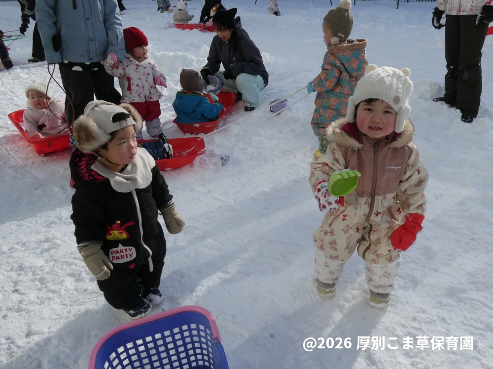 園庭で雪遊びをしている子どもたちの様子
