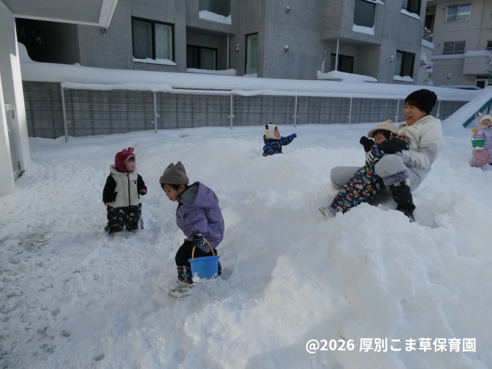 園庭で雪遊びをしている子どもたちの様子
