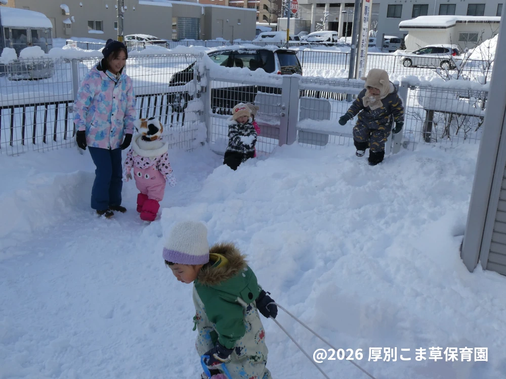 園庭で雪遊びをしている子どもたちの様子