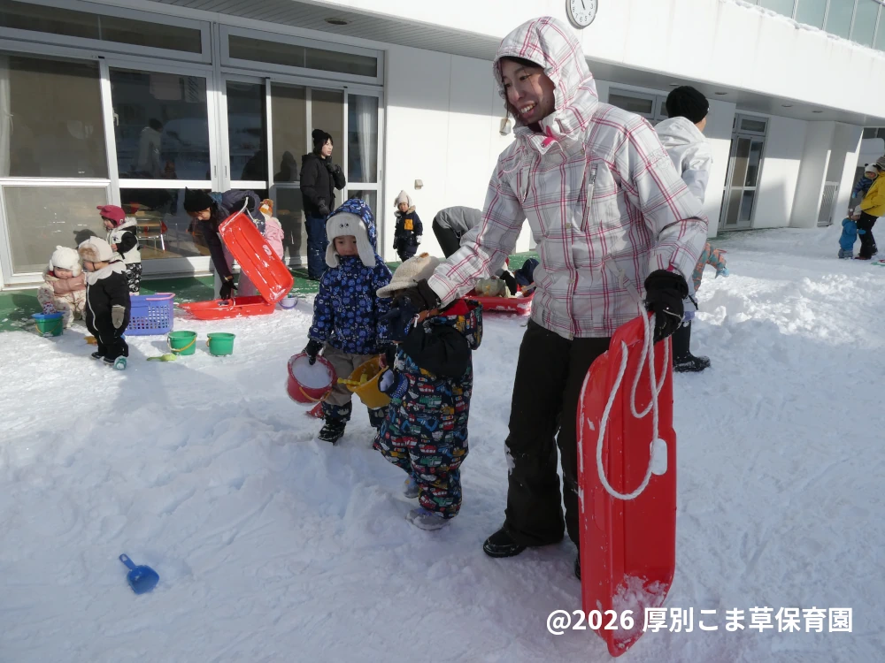 園庭で雪遊びをしている子どもたちの様子