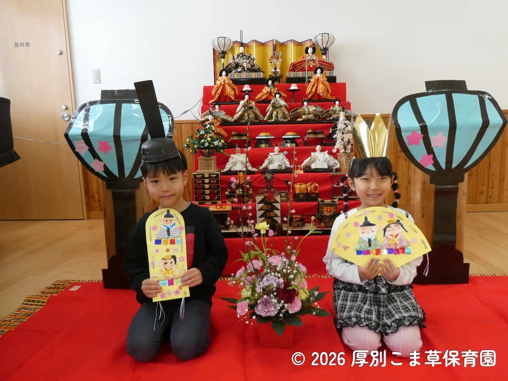 雛壇の前で写真撮影するひまわり組（５歳児）の子どもたちの様子