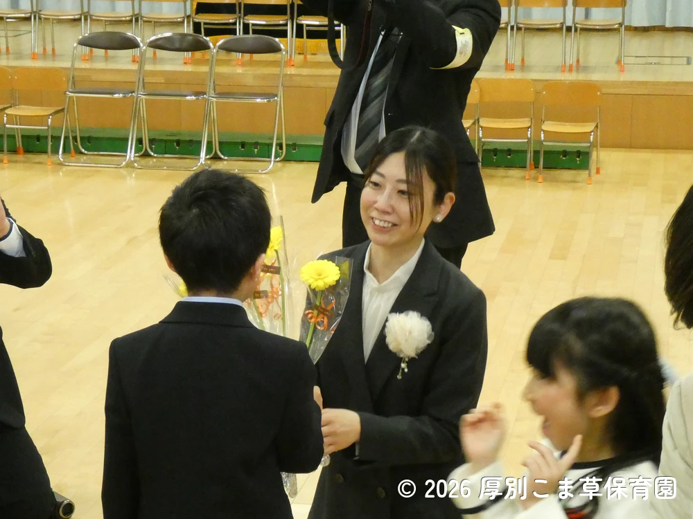担任の先生にお花を渡している子どもたちの様子