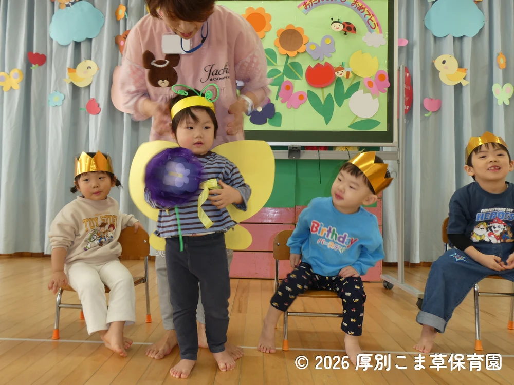 ちょうちょになって、誕生児に質問するクラスが書かれたお花を選んでくれた小さな子どもたちの様子