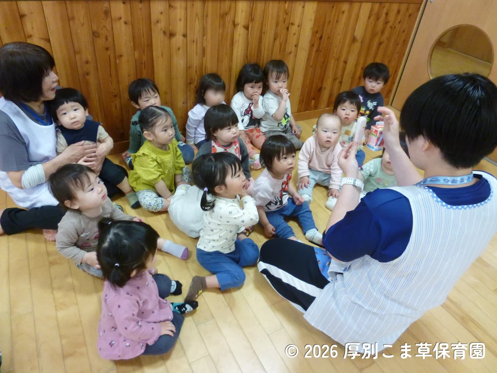 先生にジュースの飲み方を教えてもらっている子どもたちの様子