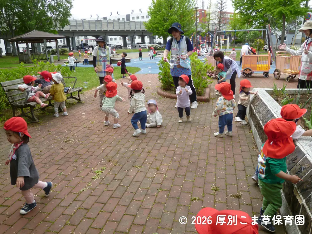 みんなでシャボン玉を追いかけて遊んでいる子どもたちの様子