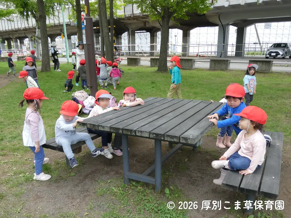 公園のベンチに座って楽しそうにしている子どもたちの様子