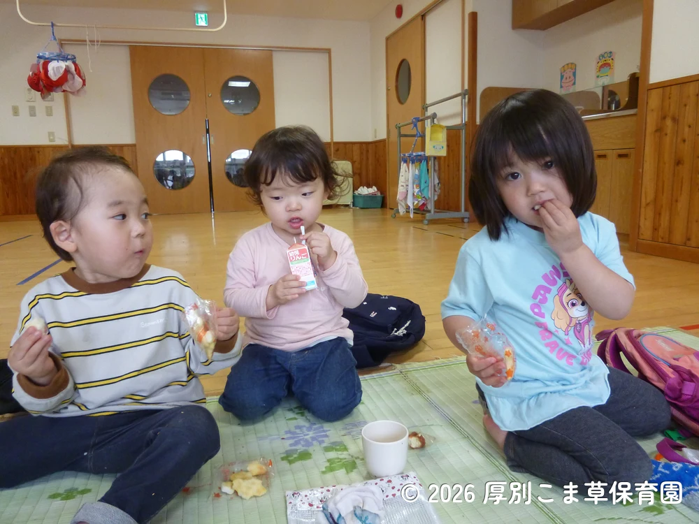 ゴザの上でお昼ごはんやおやつを食べている子どもたちの様子