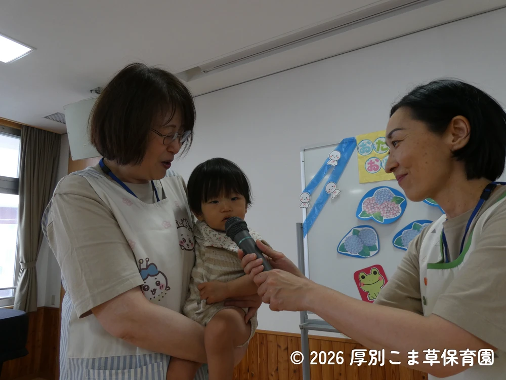 質問に答えている誕生児と担任の様子
