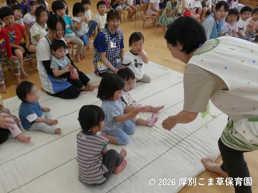 マークが書かれたかえるの舌を引っ張っている子どもたちの様子