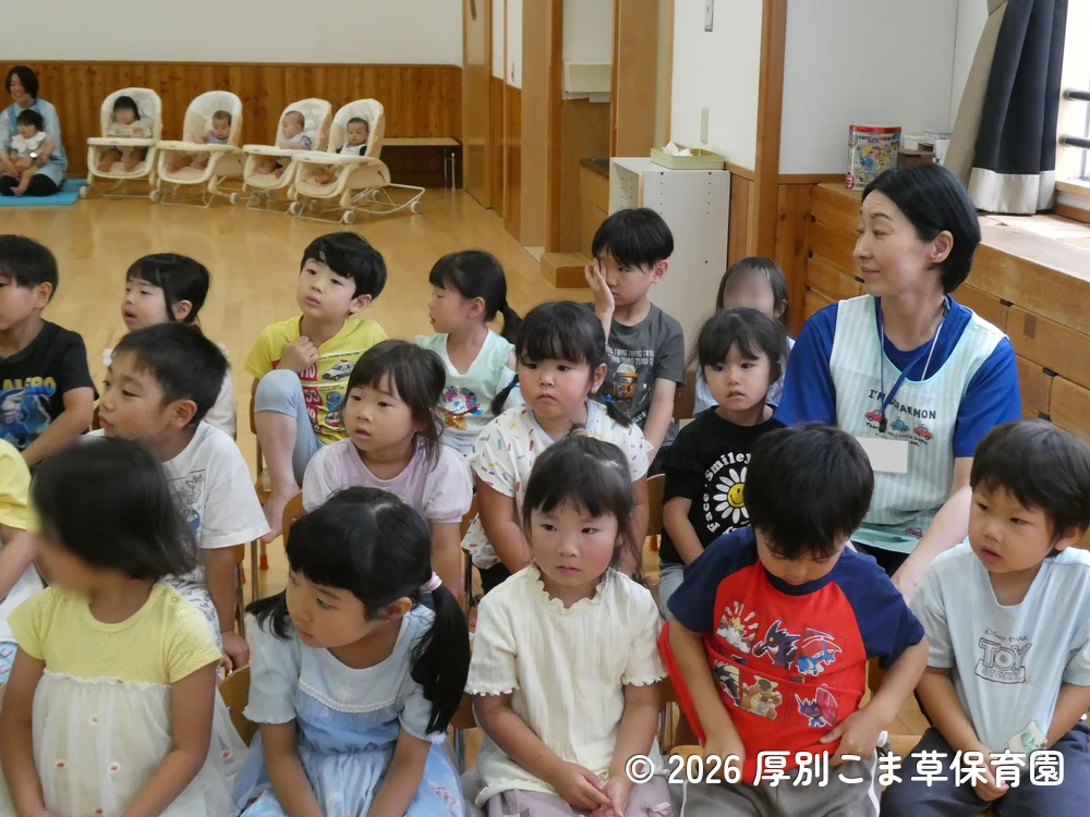 誕生会が始まる前に司会の先生のお話を聞いている子どもたちの様子