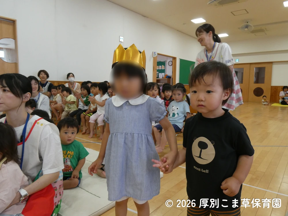 音楽に合わせて色々な表情を見せながら入場する誕生児の子どもたちの様子