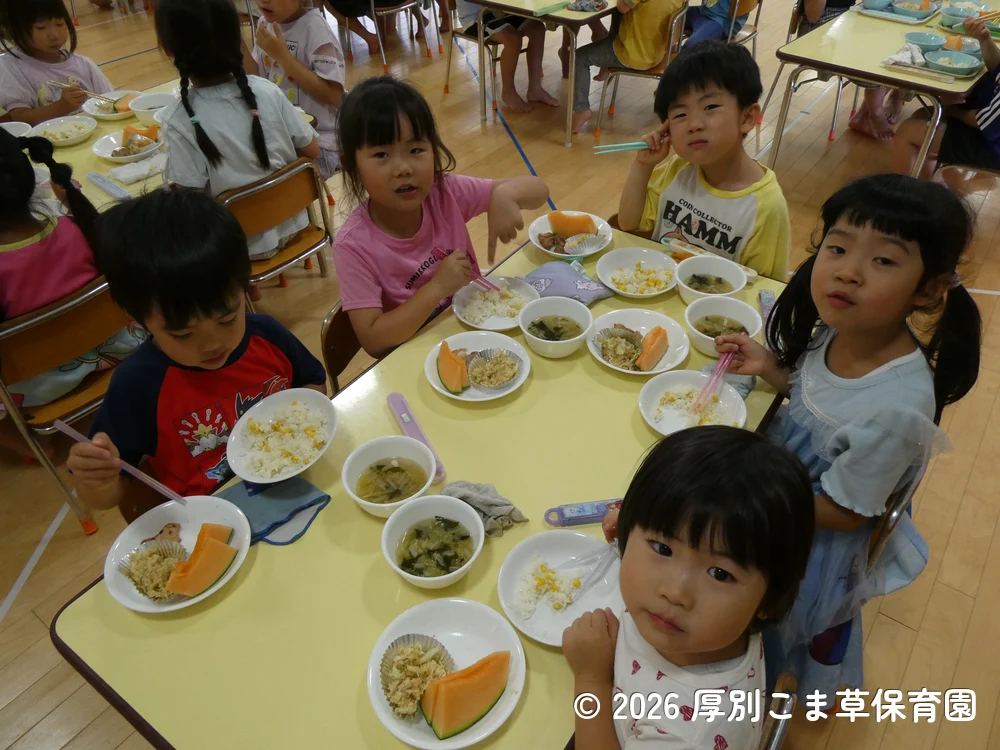 誕生会の行事食を楽しそうに食べている子どもたちの様子