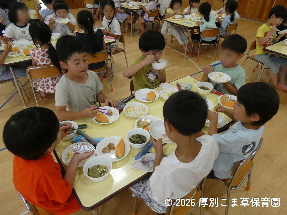 誕生会の行事食を楽しそうに食べている子どもたちの様子