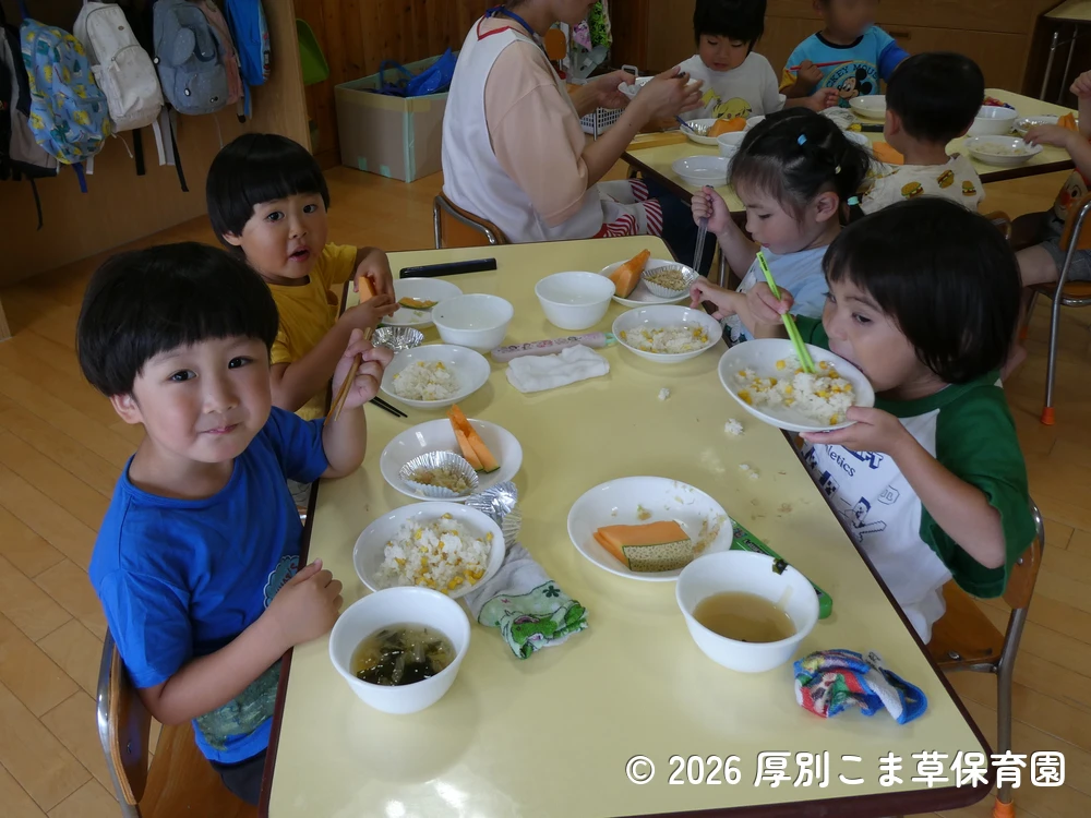 誕生会の行事食を楽しそうに食べている子どもたちの様子