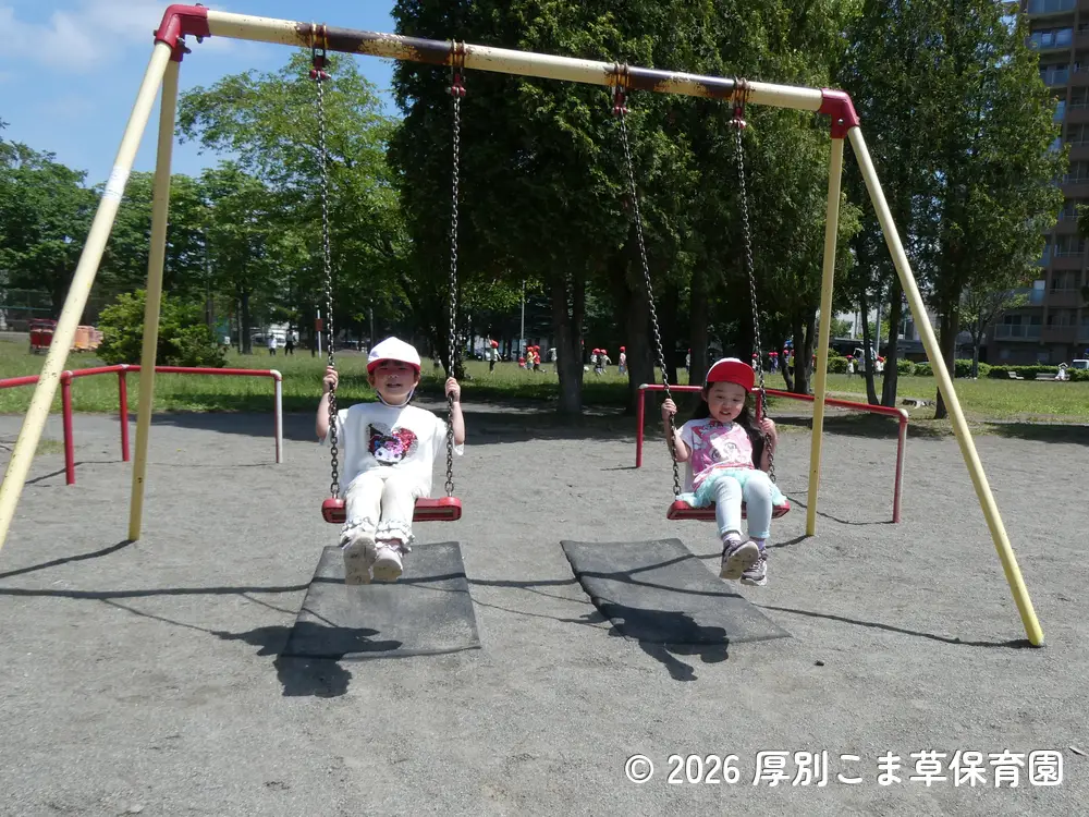 楽しそうにブランコに乗って遊んでいる子どもたちの様子
