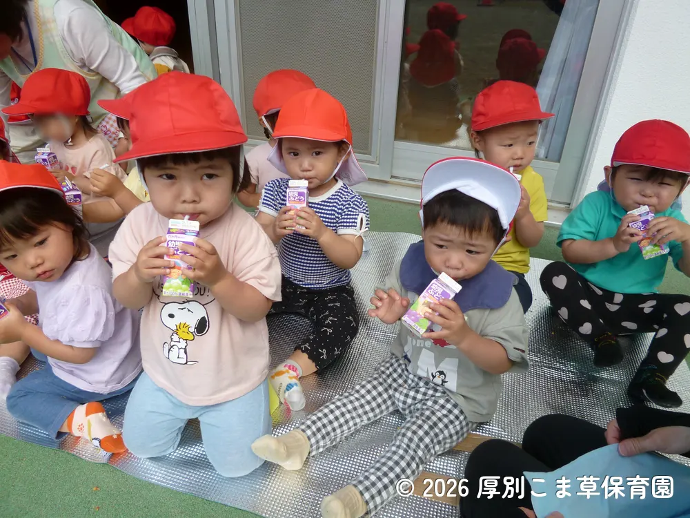 出発前にジュースを飲んでいるたんぽぽ組（１歳児）の子どもたちの様子