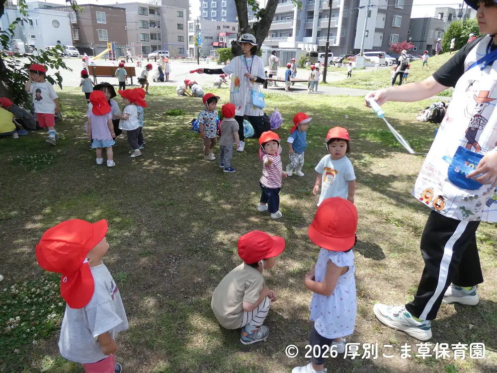 しゃぼん玉遊びをしているたんぽぽ組（１歳児）の子どもたちの様子