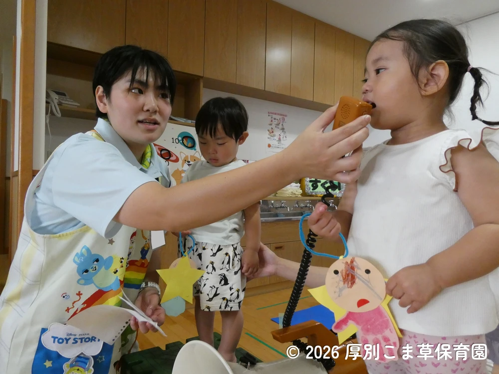七夕飾りつけ制作の内容を発表するたんぽぽ組(1歳児)の子どもたちの様子