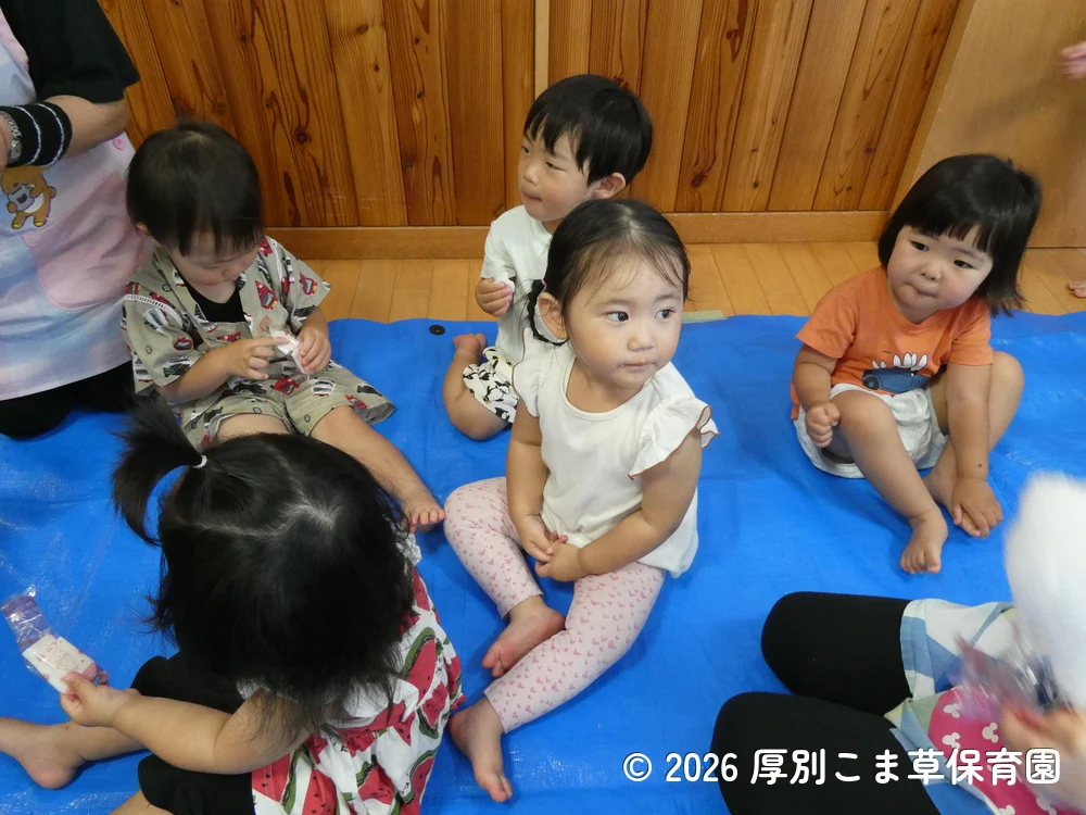 おせんべいを食べているたんぽぽ組(1歳児)の子どもたちの様子