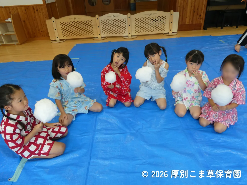 わたあめをおいしそうに食べているひまわり組(5歳児)の子どもたちの様子