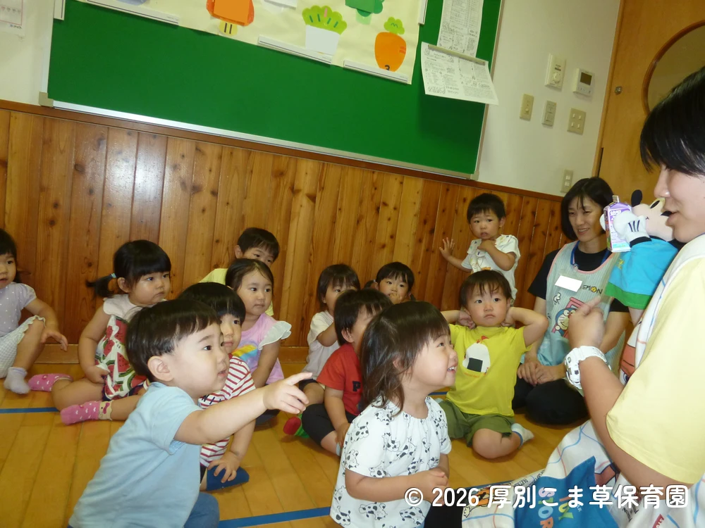 遠足に出発する前に保育園でおやつを食べているたんぽぽ組（１歳児）の子どもたちの様子