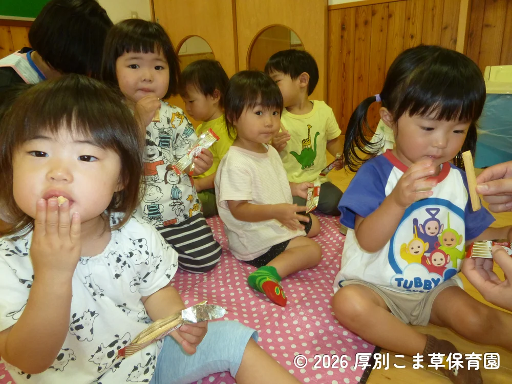 遠足に出発する前に保育園でおやつを食べているたんぽぽ組（１歳児）の子どもたちの様子