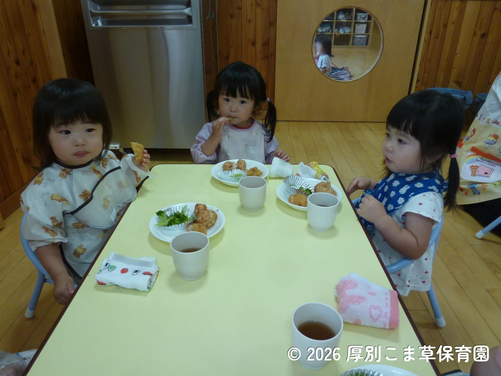 みんなで仲良くお昼ごはんを食べているたんぽぽ組（１歳児）の子どもたちの様子