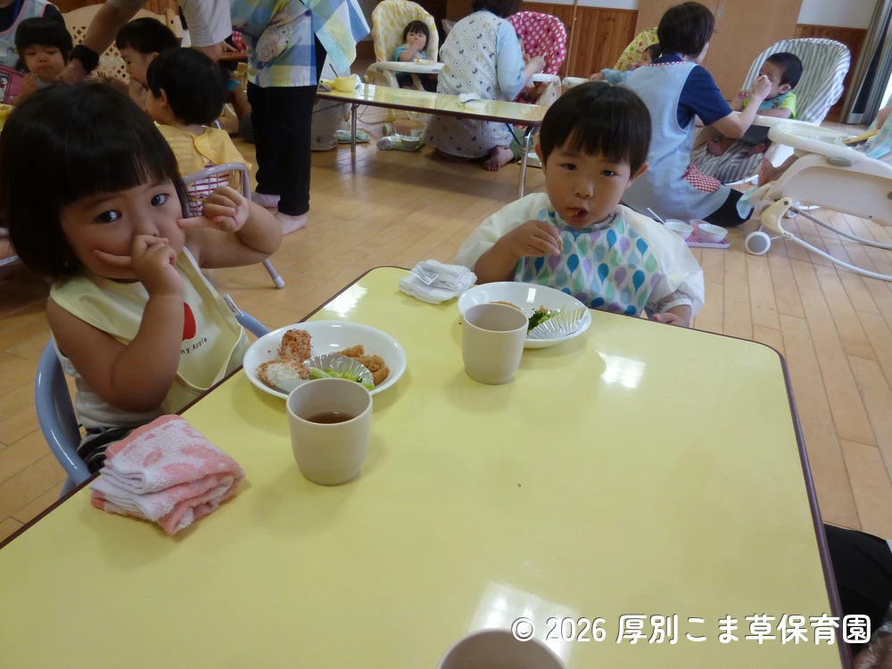 みんなで仲良くお昼ごはんを食べているたんぽぽ組（１歳児）の子どもたちの様子