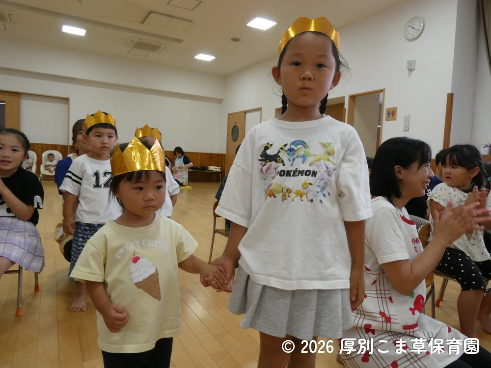 音楽に合わせて色々な表情を見せながら入場する誕生児の子どもたちの様子