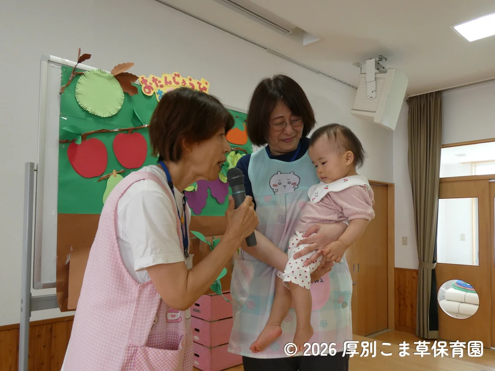 先生に抱っこされながら紹介されているたんぽぽ組（０歳児）の様子